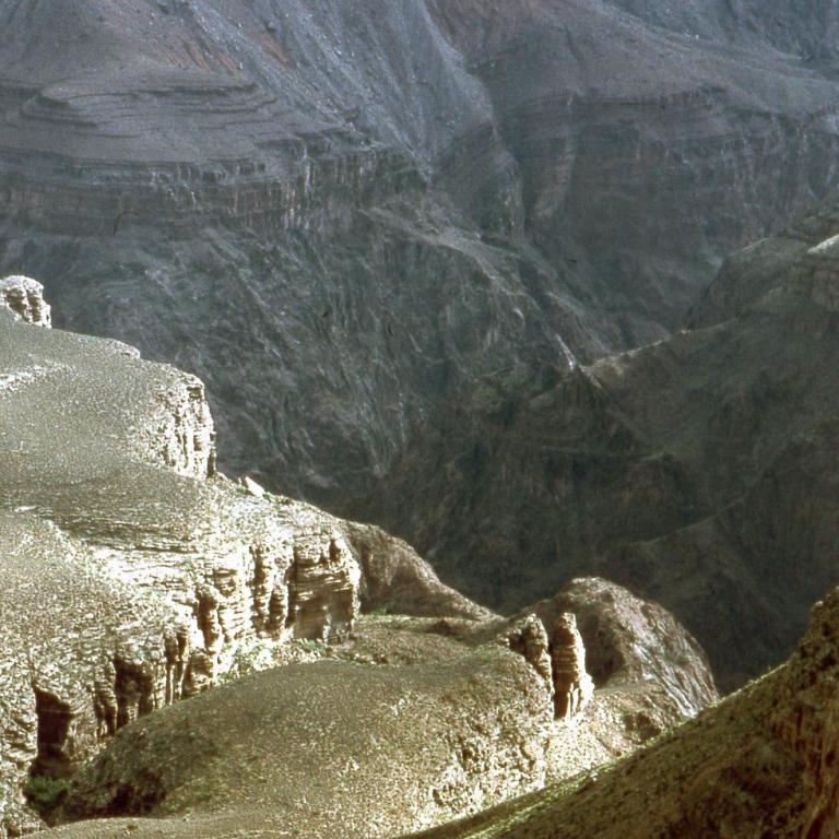 Weitwinkelaufnahme eines tiefen Canyons mit steilen Felswänden und einem erhöhten Plateau.