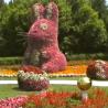 Eine große, blumengestaltete Kaninchenskulptur in einem farbenprächtigen Garten.