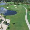 Luftaufnahme eines gut gepflegten Golfplatzes mit Wasserteichen und einem geschwungenen Weg.
