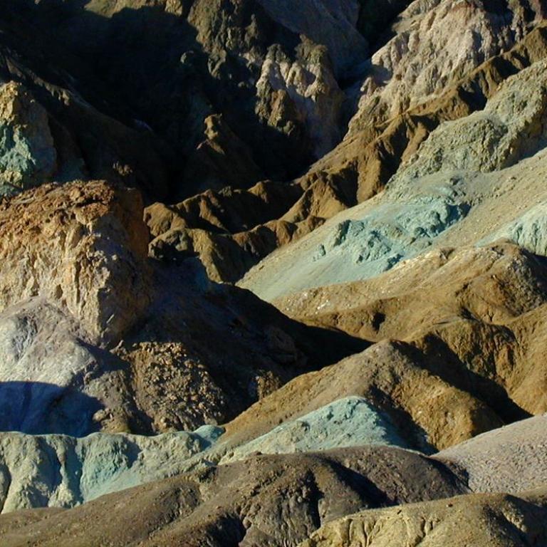 Eine hügelige Landschaft mit verschiedenen Farbtönen, die die geologische Vielfalt zeigt.