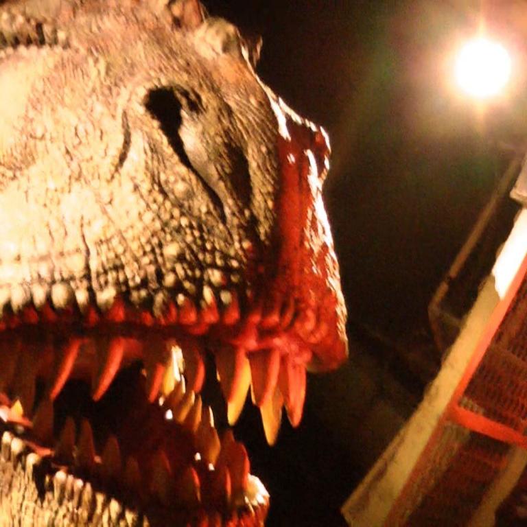 Nahaufnahme des furchteinflößenden Kopfes eines Dinosauriers mit großen, spitzen Zähnen.