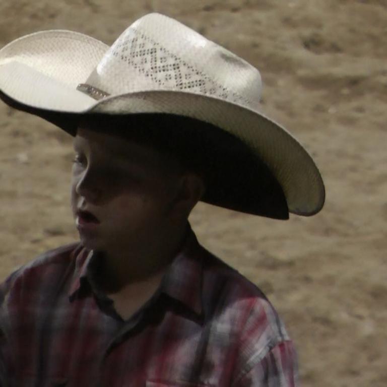 Junge in Cowboyhut und kariertem Hemd