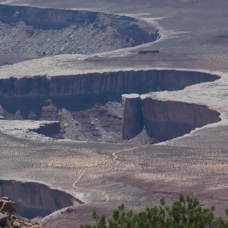Ein aus der Vogelperspektive aufgenommenes Panorama von Canyon-artigen, trockenen Landschaftsformationen.