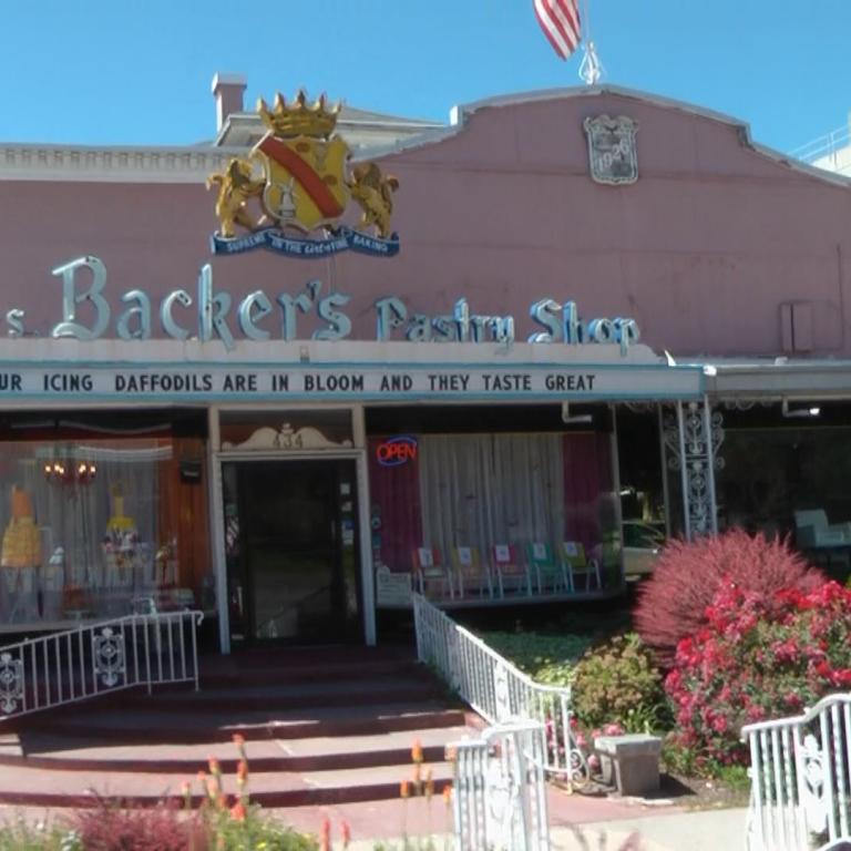 Ein Ladenlokal namens Mrs. Backer's Pastry Shop mit einem traditionellen, rosafarbenen Äußeren.